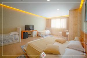 a bedroom with two beds and a television in it at NBT Hotel Reps in Kukës