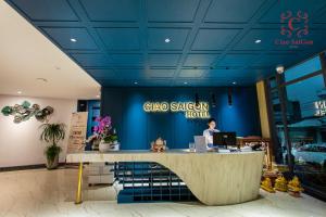 a woman standing at a counter in a chico sugar hotel at Ciao Saigon 2 Hotel in Ho Chi Minh City