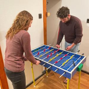 a man and woman standing next to a foosball table at Balázs Guesthouse in Budapest
