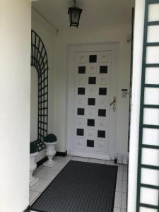 un pasillo con una puerta blanca con una alfombra negra en APPARTEMENT 70 M2 de PLAIN-PIED TERRASSE JARDIN, en Nay