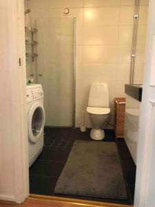 La salle de bains est pourvue de toilettes et d'un lave-linge. dans l'établissement Stor lägenhet - 150 meter från havet., à Helsingborg