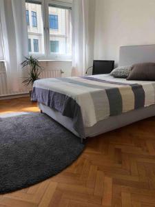 sypialnia z łóżkiem z dywanem i 2 oknami w obiekcie Stor lägenhet - 150 meter från havet. w mieście Helsingborg