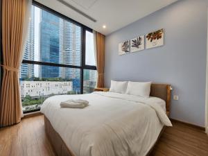 a bedroom with a large bed with a large window at Vinhomes Skylake Pham Hung-Lilyland-near Keangnam in Hanoi