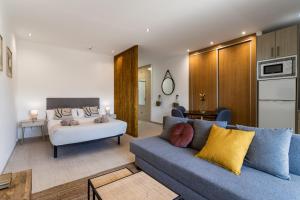 salon z kanapą i łóżkiem w obiekcie Sur Suites PYR vista mar w mieście Fuengirola