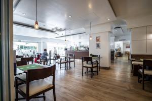 restauracja ze stołami i krzesłami oraz osoba w tle w obiekcie Sur Suites PYR vista mar w mieście Fuengirola