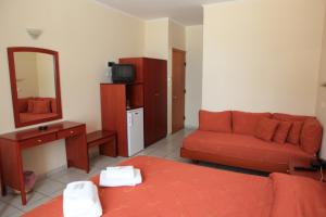 een woonkamer met een rode bank en een spiegel bij Pramataris in Monemvasia