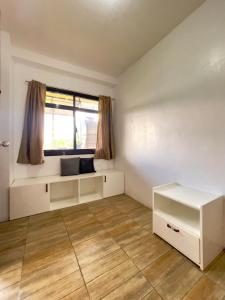 Dieses weiße Zimmer verfügt über ein Fenster und einen Schreibtisch. in der Unterkunft Andrew & Mary's Lodging House in Sagada