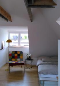 a room with a bed and a chair and a window at steenkampstudios LOFT in Hamburg