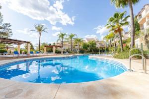 duży basen z palmami i apartamentami w obiekcie Beautiful newly renovated Apt El Palmeral RDR306 w Marbelli