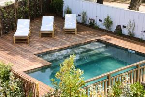 a swimming pool with two chairs and a table at Résidence Les Suites Pereire in Arcachon