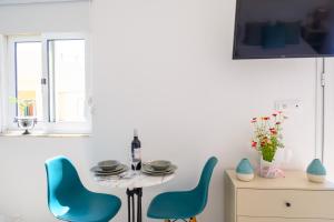 una sala da pranzo con sedie blu e tavolo di Artemis apartment first floor a Eloúnda