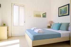 ein weißes Zimmer mit einem Bett und Handtüchern darauf in der Unterkunft Artemis apartment first floor in Elounda