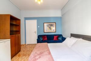 1 dormitorio con 1 cama grande y 1 sofá azul en Bravo 2 City Center Room en Athens