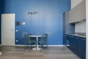 cocina con paredes azules, mesa y sillas en Smart and Comfy Apartment - Via Repubblica di San Marino, en Milán