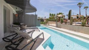un patio con sillas y una piscina en Golden Taurus Aquapark Resort, en Pineda de Mar