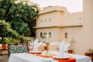 een tafel met een witte tafeldoek en wijnglazen bij Royal Heritage Haveli in Jaipur