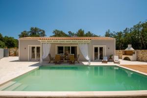 a swimming pool in front of a house at Villa Irida in Plátanos