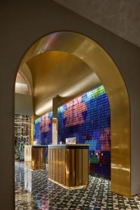 an archway in a lobby with a colorful wall at TIDE Hotel in Chaozhou