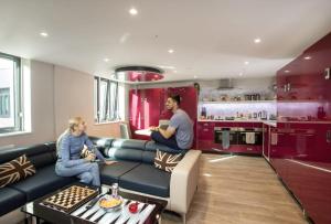 Un uomo e una donna seduti su un divano in cucina di For Students Only Ensuite Bedrooms with Shared Kitchen at Reynard House located in Leicester a Leicester