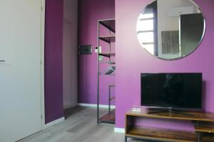 sala de estar con paredes de color púrpura y espejo en Smart and Comfy Apartment - Via Repubblica di San Marino, en Milán