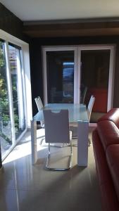 a glass table and chairs in a living room at Dom Apart Magda Rewal in Rewal +9 photos