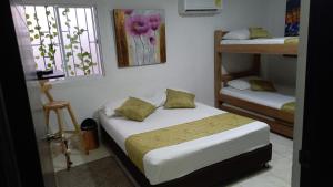 a bedroom with two beds and a window at Casa Hotel Manga Mar in Cartagena de Indias