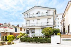 een appartementencomplex met balkons in een straat bij Hotel Il Nido in Rimini