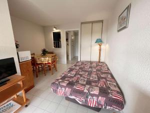 1 dormitorio con 1 cama y comedor con mesa en Appartement Fréjus, 1 pièce, 4 personnes - FR-1-226A-57, en Fréjus