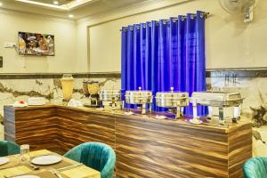 a dining room with blue chairs and a table at SM Royal Stay Hotel - Near Bangalore international Airport in Bangalore