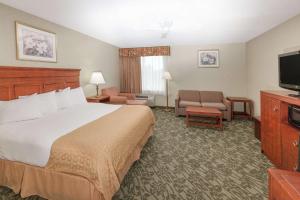 a hotel room with a bed and a flat screen tv at Baymont by Wyndham Grand Rapids N/Walker in Grand Rapids