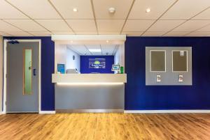 an empty room with a blue wall and a counter at Days Inn Hotel Gretna Green in Gretna Green