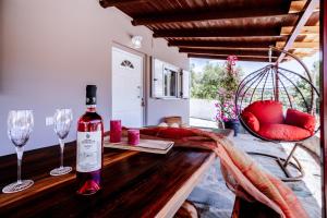 una bottiglia di vino seduta su un tavolo di legno con bicchieri da vino di Zante Sunny Mountain a Anafonítria
