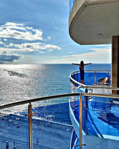 a woman standing on the deck of a cruise ship at Panorama Kvariati in Kvariati