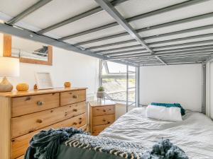 a bedroom with a bed and a wooden dresser at Sycamore Cottage in Praze an Beeble