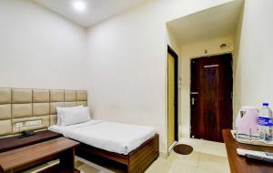 a bedroom with a bed and a desk and a door at Kyd Guest House Near Indian Museum in Kolkata