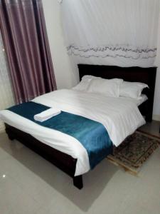 Un dormitorio con una cama grande con sábanas y almohadas blancas. en Captivating 3-Bed Apartment in Nairobi Kenya, en Nairobi 3 fotos más