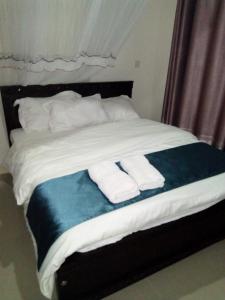 Una cama con dos toallas plegables. en Captivating 3-Bed Apartment in Nairobi Kenya, en Nairobi