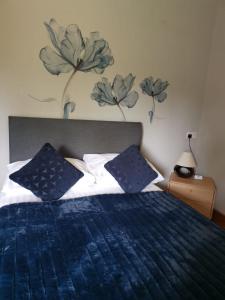 a bedroom with a blue bed with blue pillows at The Babbling Brook in Bridgwater