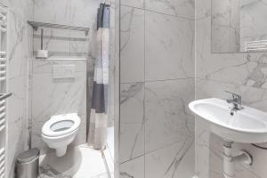 ein weißes Bad mit einem WC und einem Waschbecken in der Unterkunft Palais gare du Nord in Brüssel