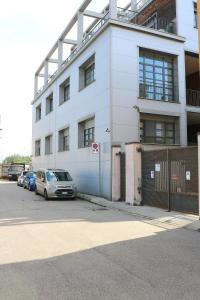 un edificio blanco con coches estacionados frente a él en Smart and Comfy Apartment - Via Repubblica di San Marino, en Milán