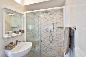 uma casa de banho branca com um lavatório e um chuveiro em Hotel Il Nido em Rimini