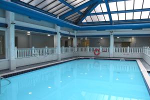 a large swimming pool with blue water in a building at Best Western Weymouth Hotel Rembrandt in Weymouth
