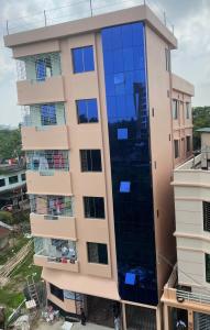 budynek z niebieskimi szklanymi panelami w obiekcie Shibgonj Bed and Breakfast w mieście Srihotto