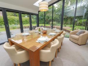 a dining room with a wooden table and chairs at Appletree Cottage in Fordingbridge