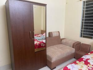a room with a door with a chair and a mirror at Shibgonj Bed and Breakfast in Sylhet