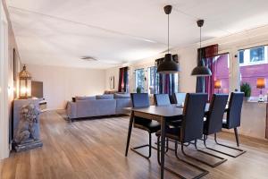 a living room with a table and chairs and a couch at Guestly Homes - 4BR Corporate Villa in Piteå