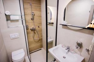 a bathroom with a shower and a toilet and a sink at Hotel Koncept Residence in Sarajevo