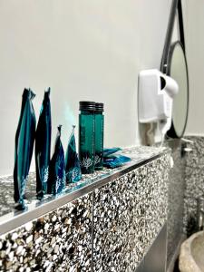 a counter with four blue glass vases on it at Favola Guesthouse Affittacamere in Nettuno