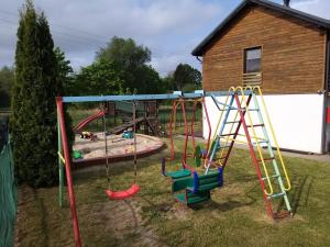 a playground with a swing set in a yard at Dom Apart Magda Rewal in Rewal