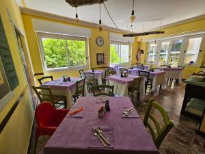 - une salle à manger avec des tables et des chaises pourpres dans l'établissement Villa Pina, à Laigueglia